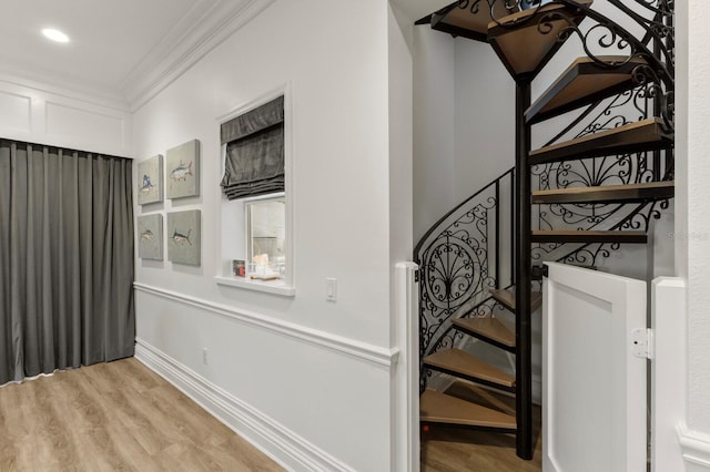 staircase featuring crown molding and wood finished floors