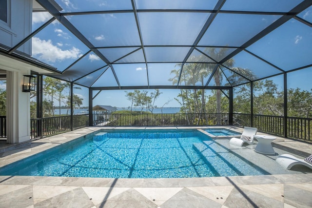 view of swimming pool featuring a pool with connected hot tub, glass enclosure, and a patio area