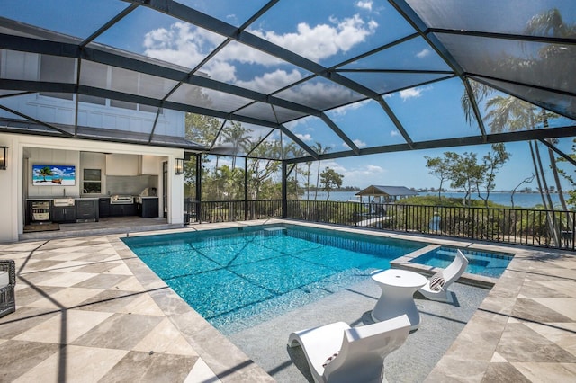 view of pool with a patio, a lanai, a pool with connected hot tub, and exterior kitchen