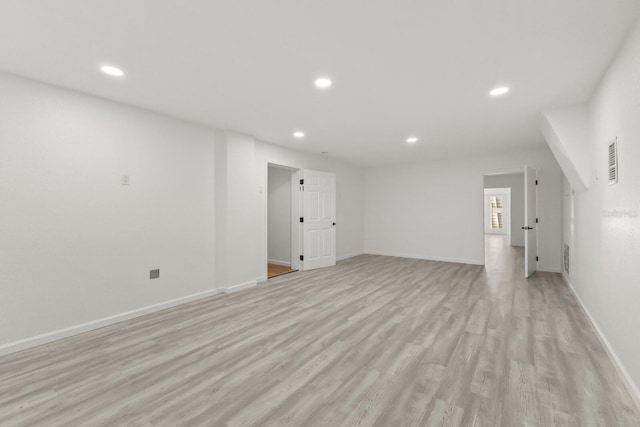 unfurnished living room with recessed lighting, light wood finished floors, and baseboards