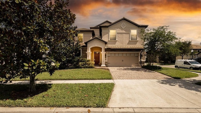 1450 Rolling Fairway Dr, Davenport, FL 33896 - view of front facade featuring decorative driveway, stucco siding, a yard, and a garage