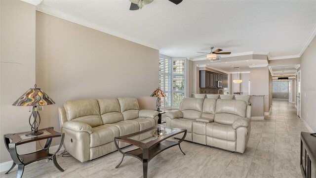 610 Riviera Dunes Way Unit 308, Palmetto, FL 34221 - living area featuring ceiling fan, crown molding, healthy amount of natural light, and baseboards