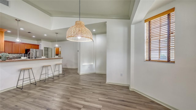 203 28th St W, Palmetto, FL 34221 - kitchen featuring stainless steel fridge with ice dispenser, light wood finished floors, a breakfast bar area, recessed lighting, and decorative backsplash