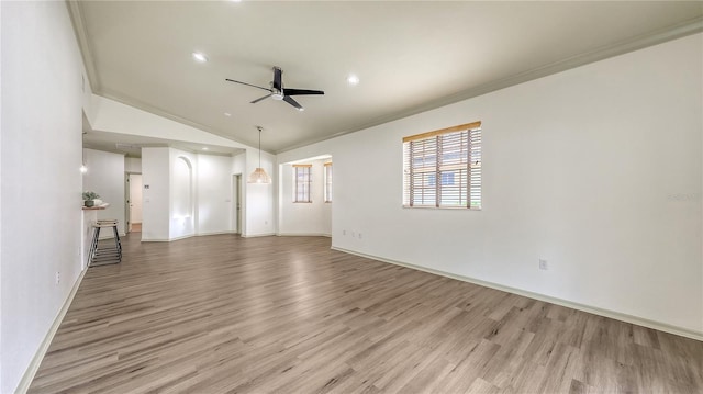 203 28th St W, Palmetto, FL 34221 - unfurnished living room featuring a ceiling fan, ornamental molding, light wood-type flooring, vaulted ceiling, and baseboards