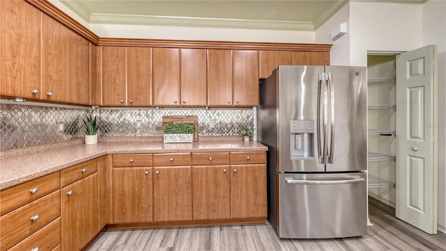 203 28th St W, Palmetto, FL 34221 - kitchen featuring stainless steel fridge with ice dispenser, light wood-style floors, tasteful backsplash, and crown molding