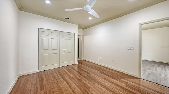 203 28th St W, Palmetto, FL 34221 - unfurnished bedroom with ornamental molding, light wood finished floors, recessed lighting, baseboards, and a closet