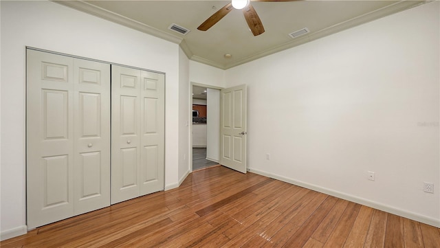 203 28th St W, Palmetto, FL 34221 - unfurnished bedroom featuring crown molding, baseboards, light wood-style floors, a closet, and ceiling fan