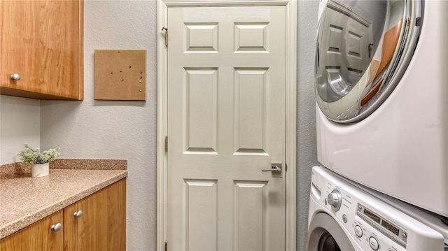 203 28th St W, Palmetto, FL 34221 - laundry room with cabinet space, stacked washer / drying machine, and a textured wall
