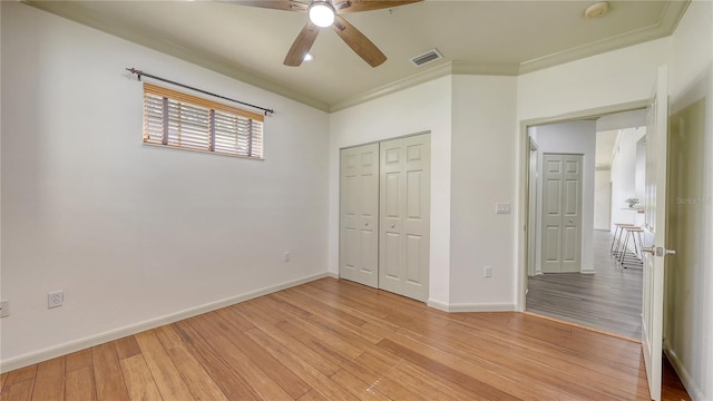 203 28th St W, Palmetto, FL 34221 - unfurnished bedroom with a closet, baseboards, light wood-style floors, ornamental molding, and ceiling fan