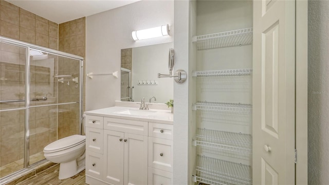 203 28th St W, Palmetto, FL 34221 - bathroom featuring a stall shower, toilet, vanity, wood finished floors, and a walk in closet