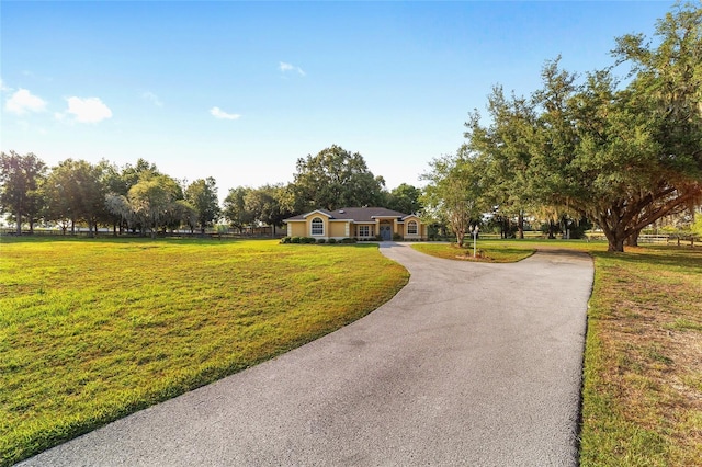 surrounding community featuring asphalt driveway and a lawn