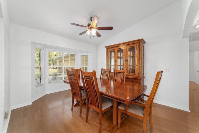 dining area featuring vaulted ceiling, ceiling fan, wood finished floors, and baseboards