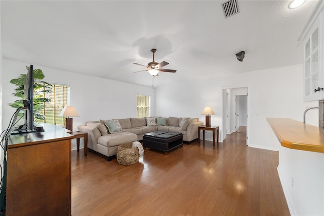 living room featuring a ceiling fan, healthy amount of natural light, baseboards, and dark wood-style floors