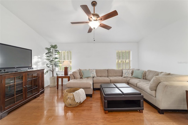 living room with plenty of natural light, a ceiling fan, light wood-style floors, and vaulted ceiling