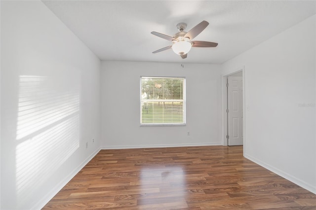 unfurnished room with ceiling fan, wood finished floors, and baseboards