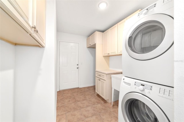laundry area featuring cabinet space, estacked washer and dryer, and baseboards