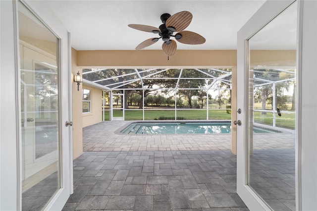 swimming pool featuring a patio area, a ceiling fan, and a lanai