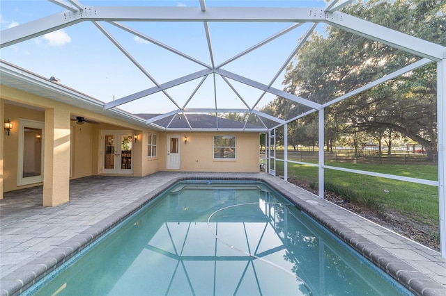 outdoor pool with french doors, a patio area, a lawn, and a lanai