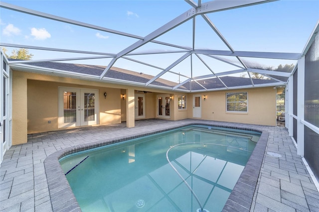 outdoor pool with french doors, a patio, ceiling fan, and glass enclosure