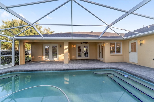 rear view of property featuring french doors, stucco siding, a patio, a lanai, and an outdoor pool