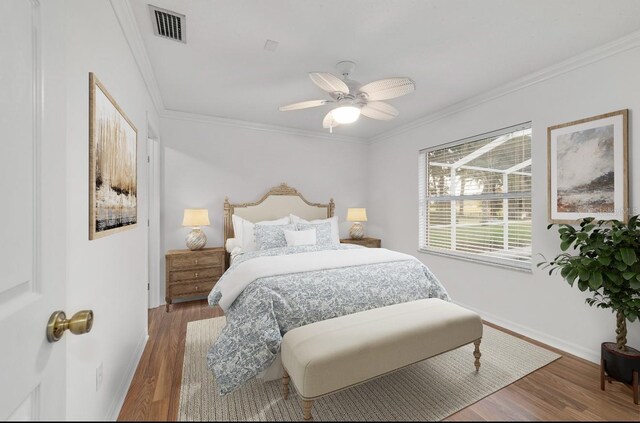 bedroom featuring ornamental molding, wood finished floors, baseboards, and a ceiling fan
