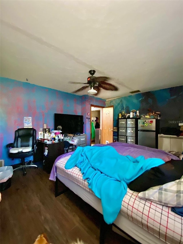 bedroom featuring wood finished floors, freestanding refrigerator, and a ceiling fan