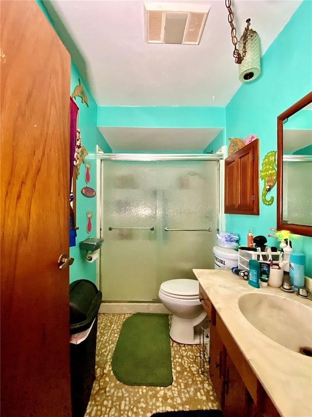 bathroom with a stall shower, vanity, and toilet