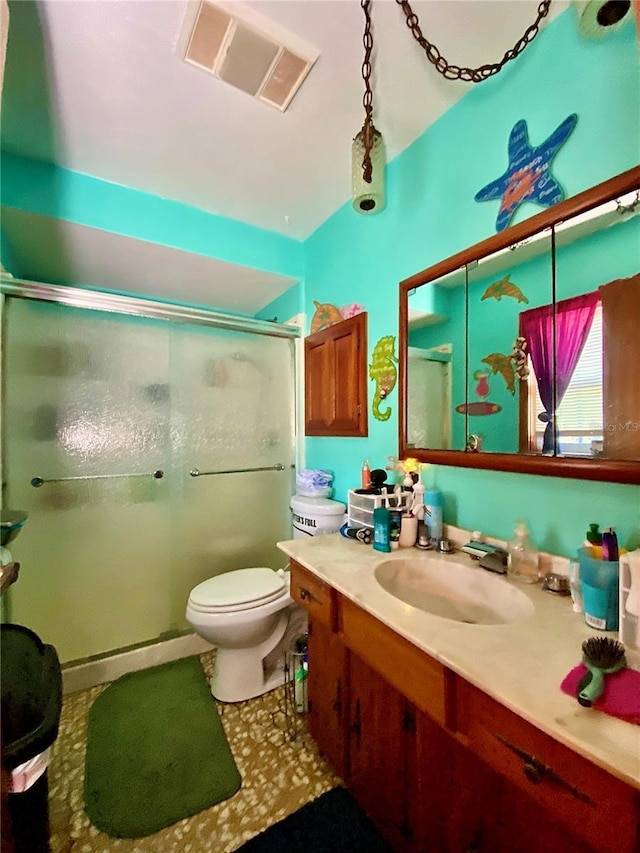 bathroom featuring a shower stall, vanity, and toilet