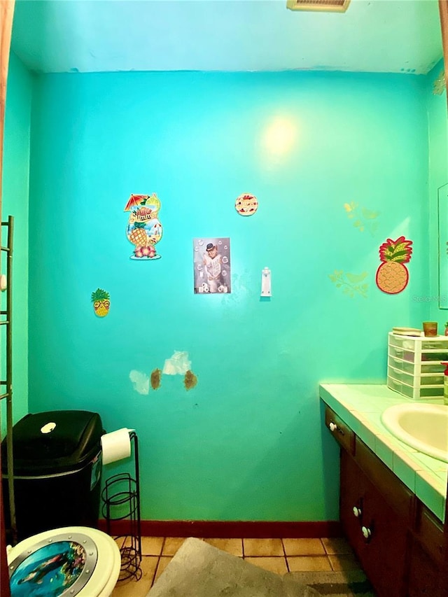 bathroom featuring tile patterned floors, baseboards, vanity, and toilet