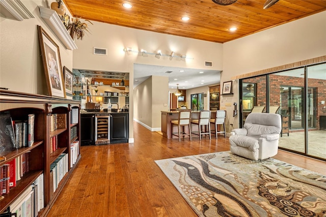 140 Cowpen Ln, Sarasota, FL 34240 - living area with wood ceiling, wine cooler, a high ceiling, and hardwood / wood-style flooring