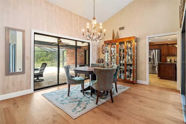 140 Cowpen Ln, Sarasota, FL 34240 - dining space featuring high vaulted ceiling, baseboards, a chandelier, and light wood-type flooring