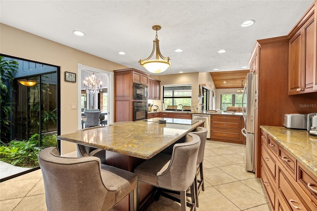 140 Cowpen Ln, Sarasota, FL 34240 - kitchen featuring black appliances, recessed lighting, a kitchen breakfast bar, a sink, and light stone countertops
