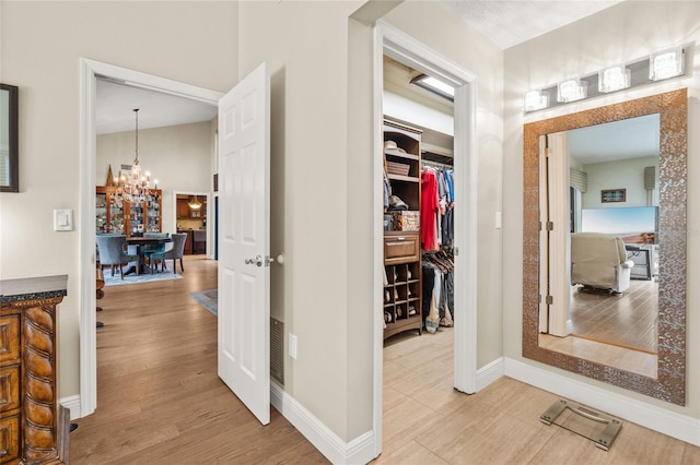 140 Cowpen Ln, Sarasota, FL 34240 - corridor with a chandelier, light wood-style flooring, and baseboards