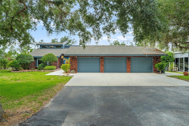140 Cowpen Ln, Sarasota, FL 34240 - mid-century modern home with driveway, a front yard, an attached garage, and roof with shingles
