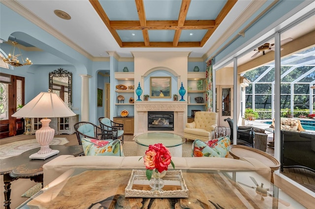 living room with a sunroom, a high ceiling, coffered ceiling, beam ceiling, and a glass covered fireplace