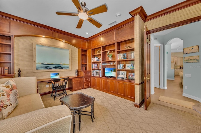 home office featuring ceiling fan, crown molding, baseboards, built in features, and arched walkways