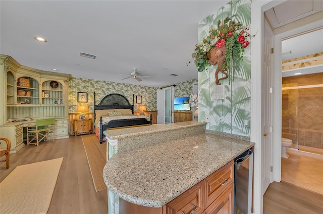 bedroom with wallpapered walls, bar area, light wood-style floors, and recessed lighting