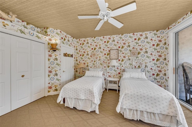 bedroom with wallpapered walls, light floors, and a ceiling fan