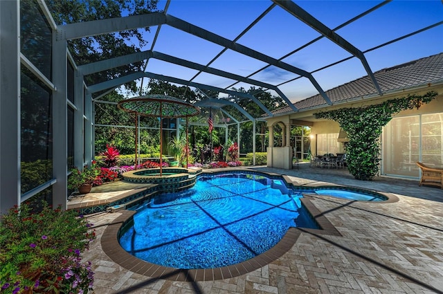 view of pool with a pool with connected hot tub, a patio, and a lanai