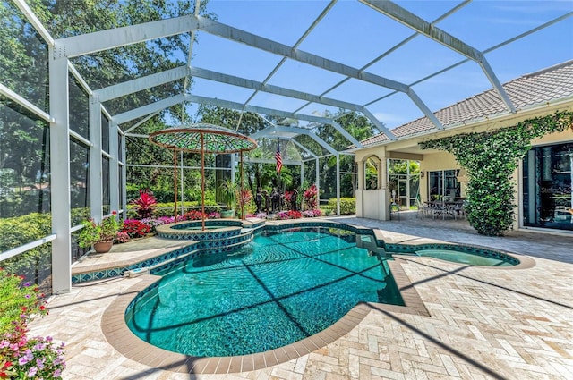 view of pool with a pool with connected hot tub, a patio, and a lanai