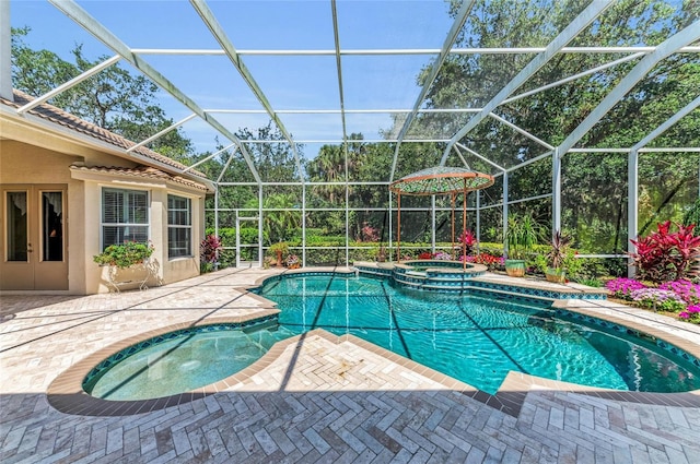 view of swimming pool featuring a pool with connected hot tub, a patio area, and a lanai