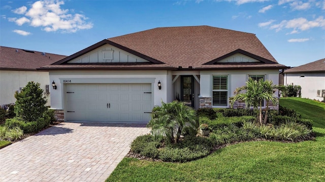 10414 Spring Tide Way, Parrish, FL 34219 - view of front of home with decorative driveway, stone siding, a garage, and a front lawn
