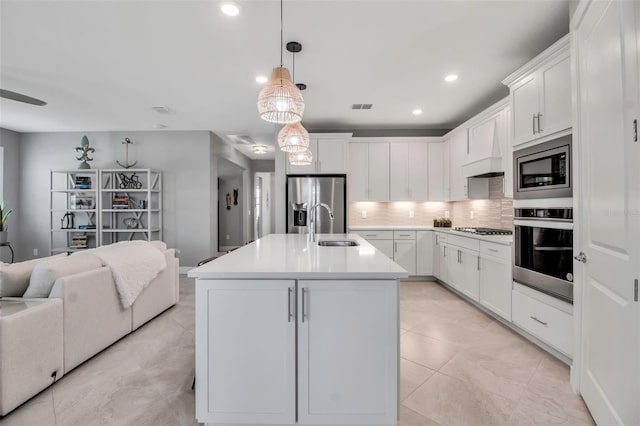 10414 Spring Tide Way, Parrish, FL 34219 - kitchen featuring appliances with stainless steel finishes, open floor plan, a sink, tasteful backsplash, and white cabinetry