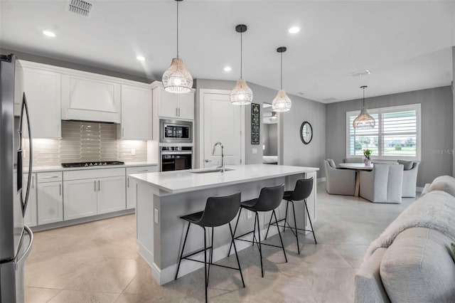 10414 Spring Tide Way, Parrish, FL 34219 - kitchen featuring stainless steel appliances, a sink, premium range hood, white cabinetry, and recessed lighting