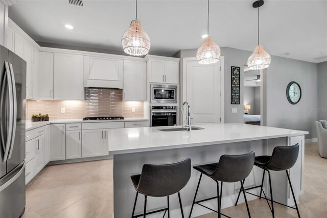 10414 Spring Tide Way, Parrish, FL 34219 - kitchen with a sink, stainless steel appliances, backsplash, custom exhaust hood, and white cabinets