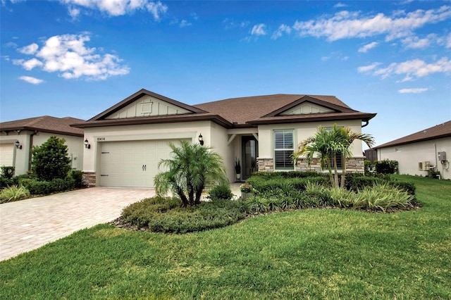 10414 Spring Tide Way, Parrish, FL 34219 - ranch-style home with stone siding, a garage, a front lawn, decorative driveway, and stucco siding