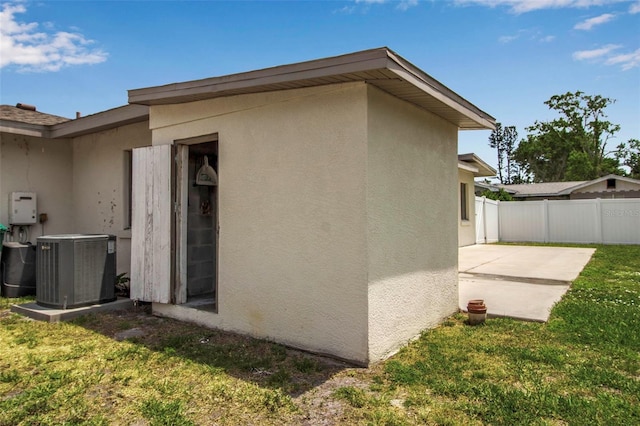 view of property exterior featuring stucco siding, central AC unit, and a patio area