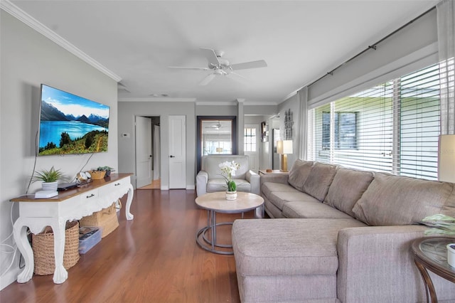 living area with wood finished floors, ceiling fan, crown molding, and baseboards
