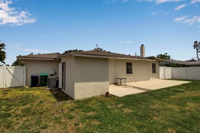 rear view of house featuring a gate, a patio area, stucco siding, and cooling unit