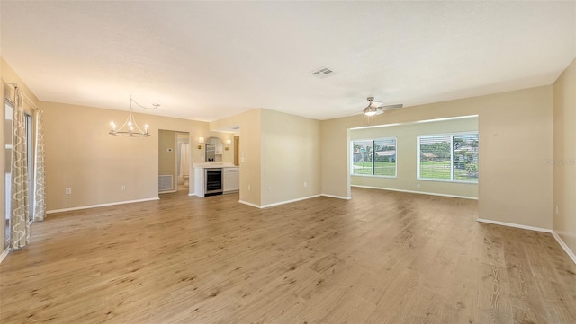 445 Matisse Cir S Unit 445, Nokomis, FL 34275 - unfurnished living room with beverage cooler, a chandelier, light wood-style floors, and baseboards